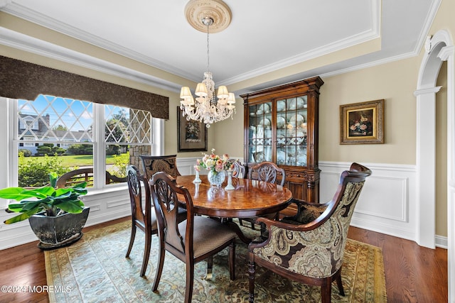 dining area featuring a tray ceiling, crown molding, a chandelier, and wood-type flooring