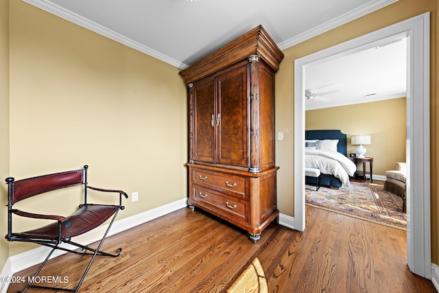 sitting room with ceiling fan, crown molding, and light hardwood / wood-style floors