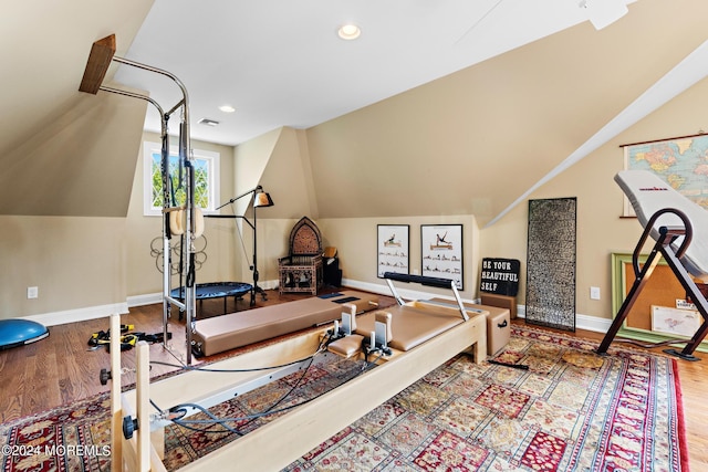 exercise area with lofted ceiling and hardwood / wood-style flooring