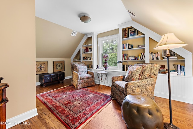 living area with hardwood / wood-style flooring and built in shelves