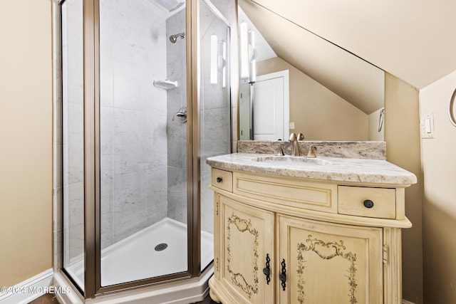 bathroom featuring a shower with door, vanity, and lofted ceiling