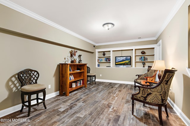 sitting room featuring hardwood / wood-style floors, crown molding, and built in shelves