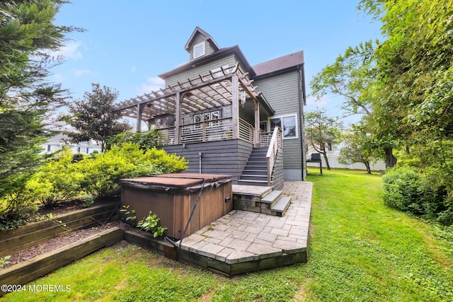 back of house with a hot tub, a pergola, and a yard