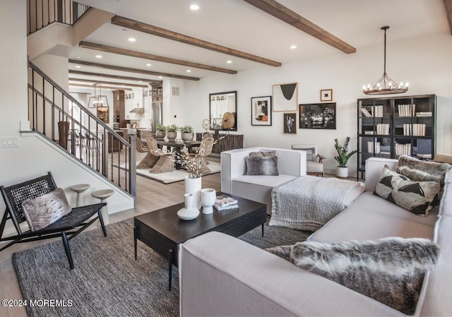 living room with hardwood / wood-style floors, beamed ceiling, and a chandelier