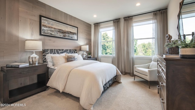 carpeted bedroom featuring wood walls