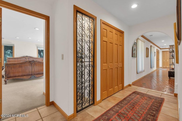 tiled foyer entrance with baseboards, arched walkways, and recessed lighting