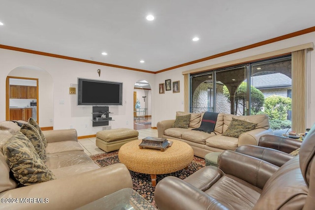 tiled living area with arched walkways, baseboards, recessed lighting, and ornamental molding
