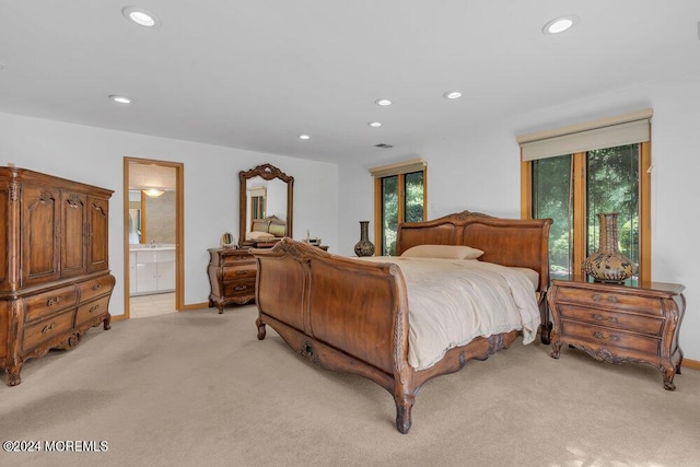 bedroom with connected bathroom, recessed lighting, baseboards, and light colored carpet