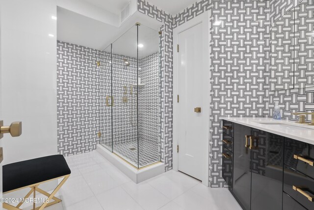 bathroom featuring a shower with door, tile walls, tile patterned floors, and vanity