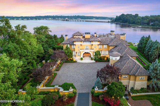 aerial view at dusk featuring a water view