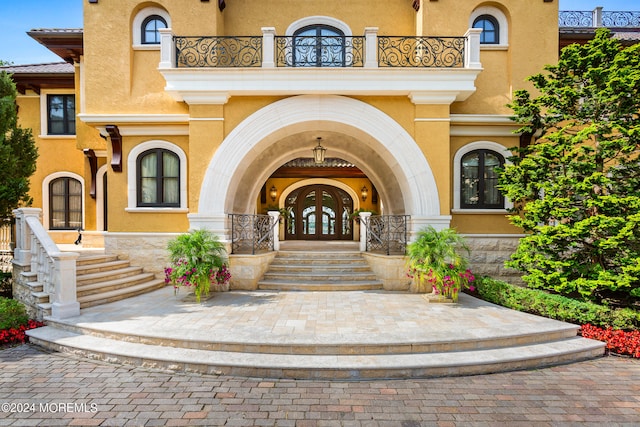 entrance to property featuring a balcony and french doors