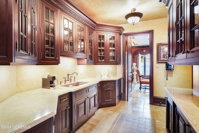 kitchen featuring sink, ornamental molding, and light tile patterned floors