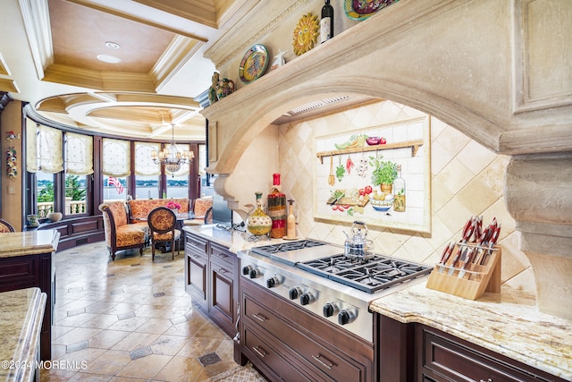 kitchen with coffered ceiling, ornamental molding, light stone countertops, decorative light fixtures, and dark brown cabinets