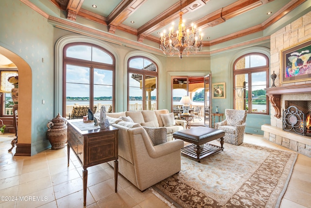 tiled living room with a fireplace, coffered ceiling, ornamental molding, a towering ceiling, and a notable chandelier