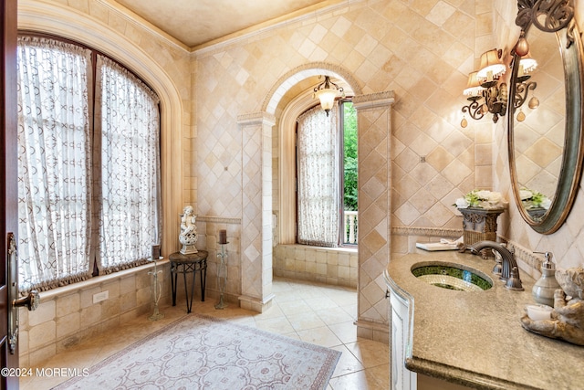 bathroom featuring sink, tile patterned flooring, tile walls, a bathtub, and crown molding