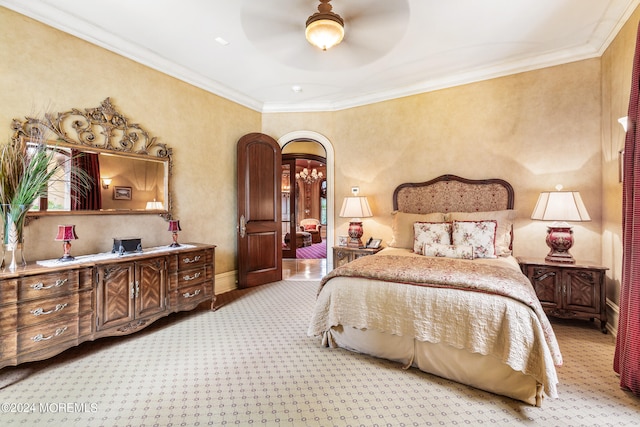 bedroom with ceiling fan, ornamental molding, and light carpet