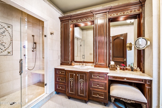 bathroom featuring tile patterned flooring, tile walls, a shower with door, and vanity