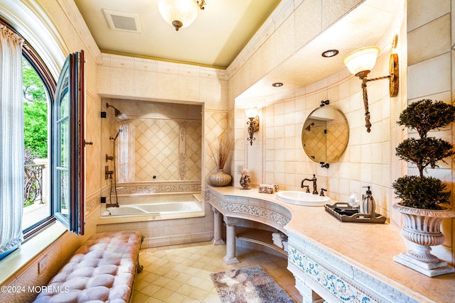 bathroom featuring vanity, a healthy amount of sunlight, tile patterned floors, and tile walls