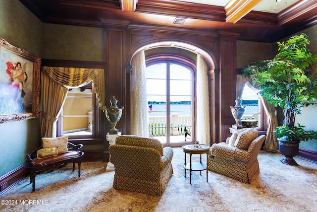 sitting room featuring coffered ceiling, ornamental molding, and a water view