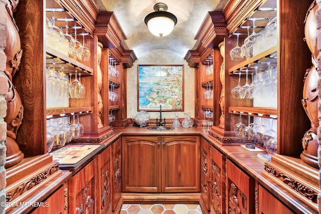 bar with sink and light tile patterned floors