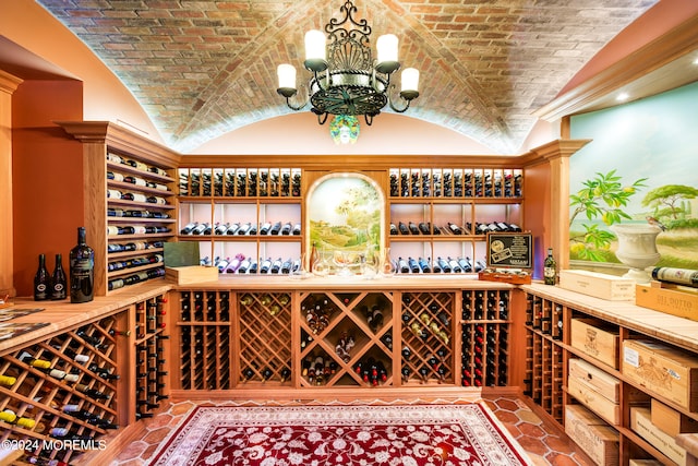 wine room featuring brick ceiling, an inviting chandelier, and lofted ceiling