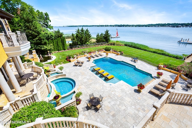 view of pool with a patio area, a lawn, a water view, and a hot tub