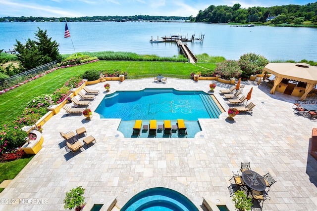 view of swimming pool with a patio, a jacuzzi, a water view, and a lawn