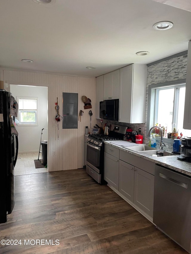 kitchen with sink, hardwood / wood-style flooring, electric panel, white cabinetry, and black appliances