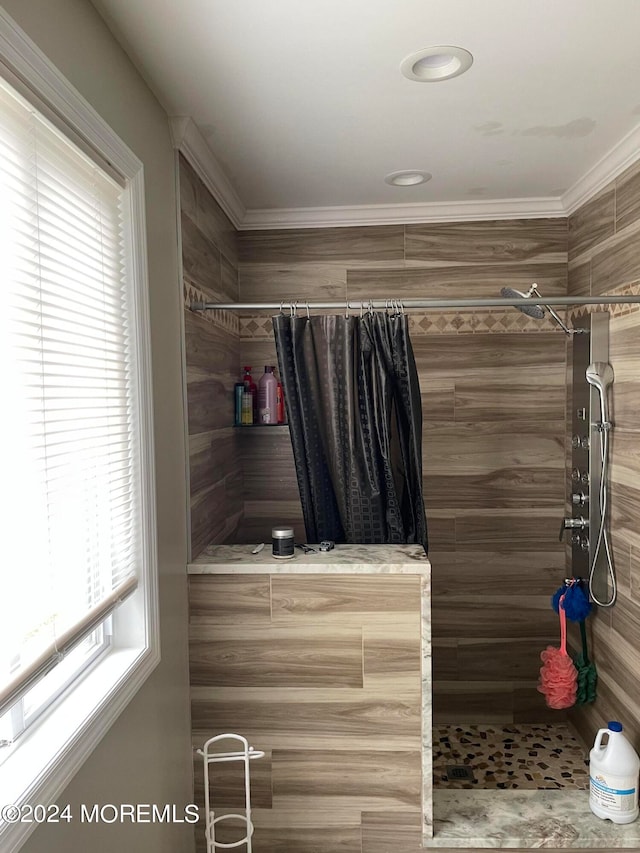 bathroom with plenty of natural light, crown molding, and walk in shower