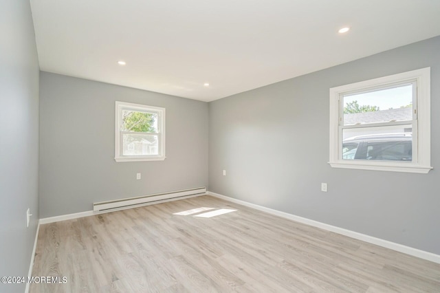 unfurnished room with light hardwood / wood-style floors and baseboard heating