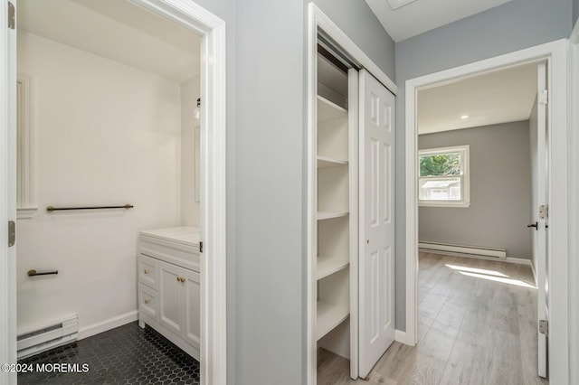 bathroom with hardwood / wood-style flooring, baseboard heating, and vanity