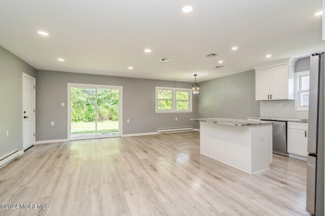 kitchen with light wood-type flooring, white cabinets, light stone counters, a baseboard heating unit, and a center island