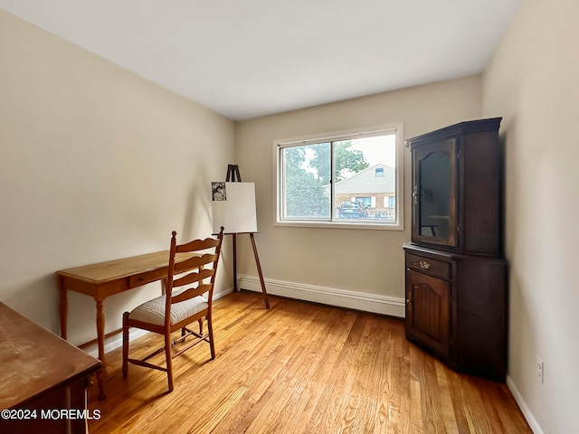 office area with a baseboard heating unit and light hardwood / wood-style flooring