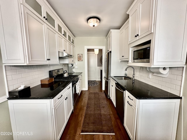 kitchen featuring stainless steel appliances, glass insert cabinets, white cabinetry, and under cabinet range hood