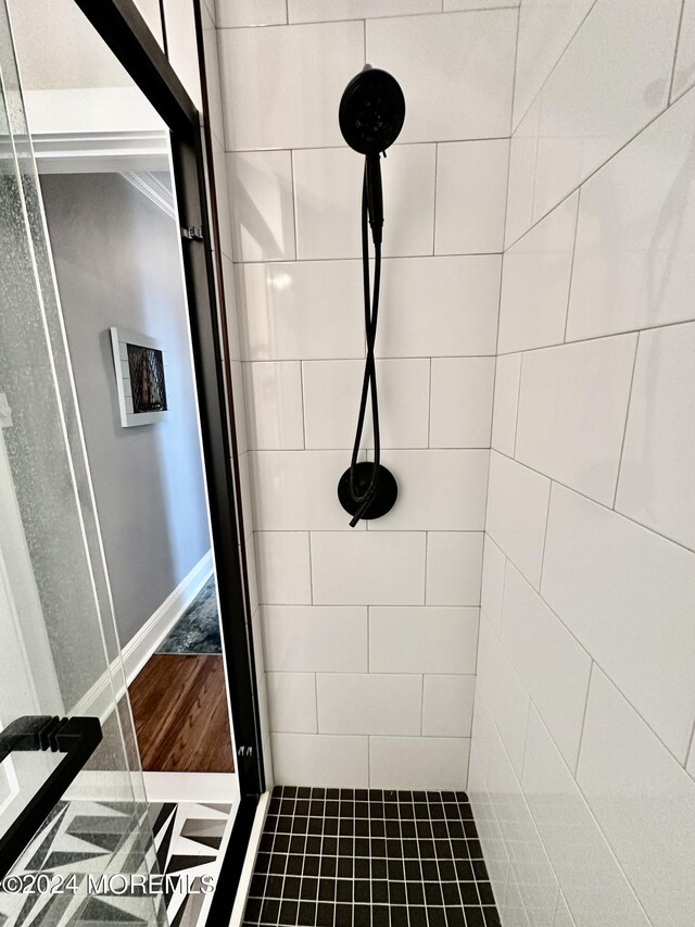 full bath featuring baseboards and tiled shower