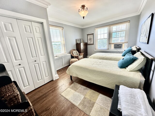 bedroom featuring cooling unit, a closet, ornamental molding, and dark wood-type flooring