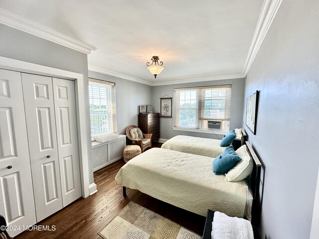 bedroom with dark wood-style floors, ornamental molding, a closet, and cooling unit