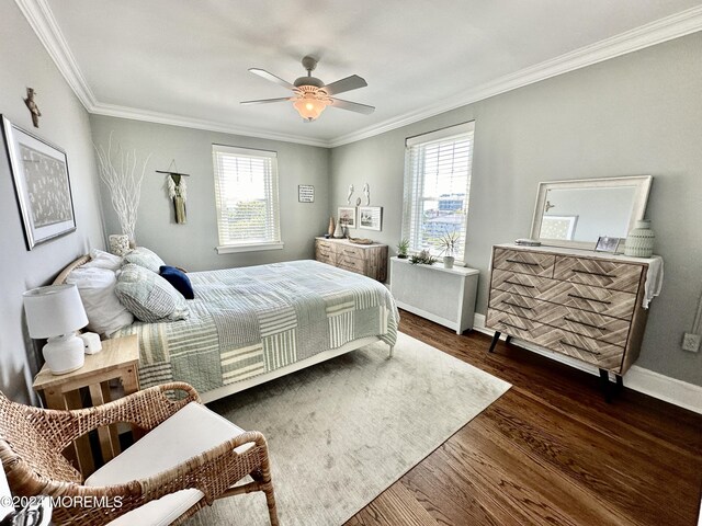 bedroom featuring baseboards, multiple windows, ornamental molding, and dark wood finished floors