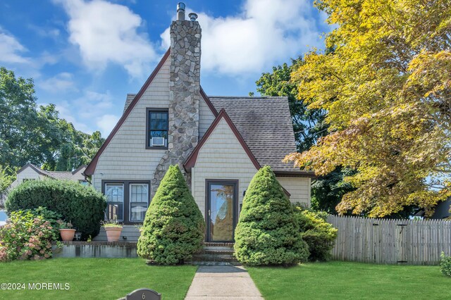 english style home featuring a front yard