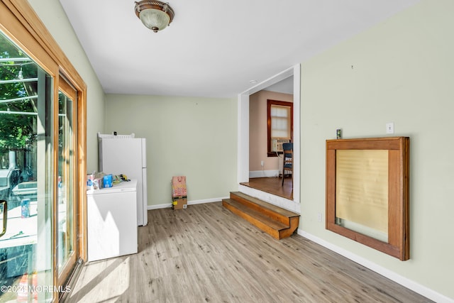 interior space featuring light hardwood / wood-style floors, washer / dryer, and white refrigerator