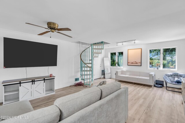 living room featuring light wood-type flooring, rail lighting, and ceiling fan