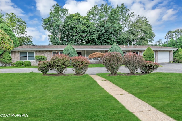 single story home featuring a garage and a front lawn