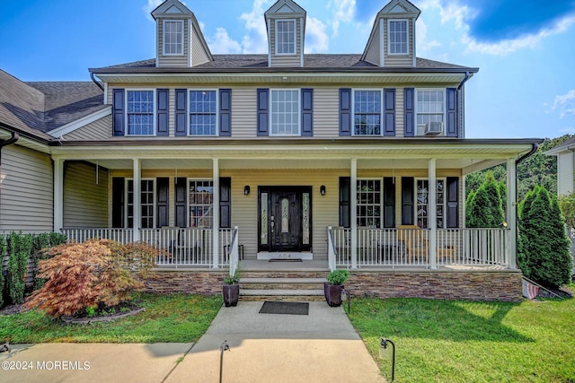 view of front of property featuring cooling unit, a porch, and a front lawn