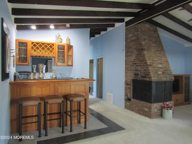 bar featuring carpet, lofted ceiling with beams, and a brick fireplace