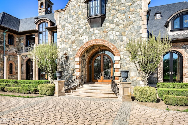 86 Montrose Rd, Colts Neck, NJ 07722 - view of exterior entry with stone siding, brick siding, and french doors