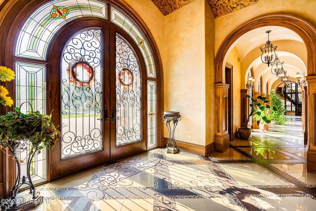 86 Montrose Rd, Colts Neck, NJ 07722 - foyer entrance featuring a chandelier, baseboards, arched walkways, lofted ceiling, and french doors