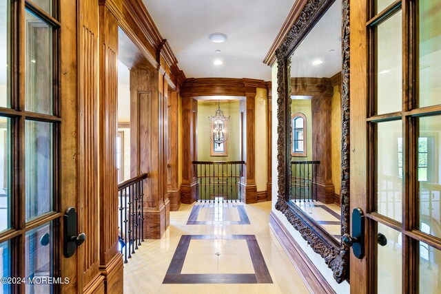 hallway with french doors, decorative columns, and ornamental molding