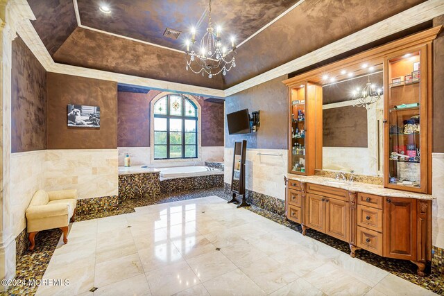 bathroom with a tub to relax in, a notable chandelier, tile walls, a tray ceiling, and vanity