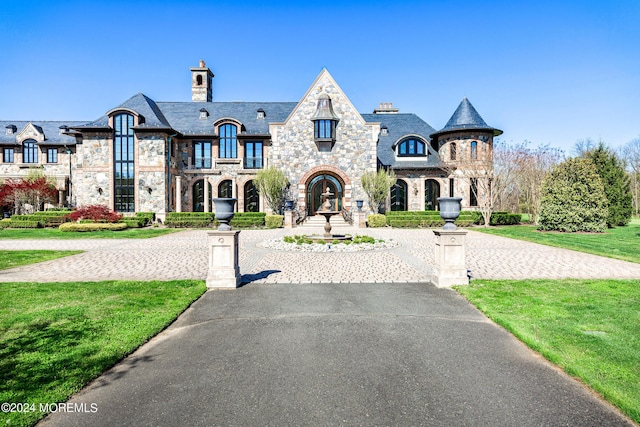 86 Montrose Rd, Colts Neck, NJ 07722 - french provincial home with a high end roof, stone siding, a chimney, and curved driveway