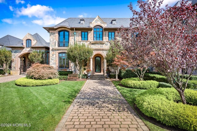 french country inspired facade with a front yard